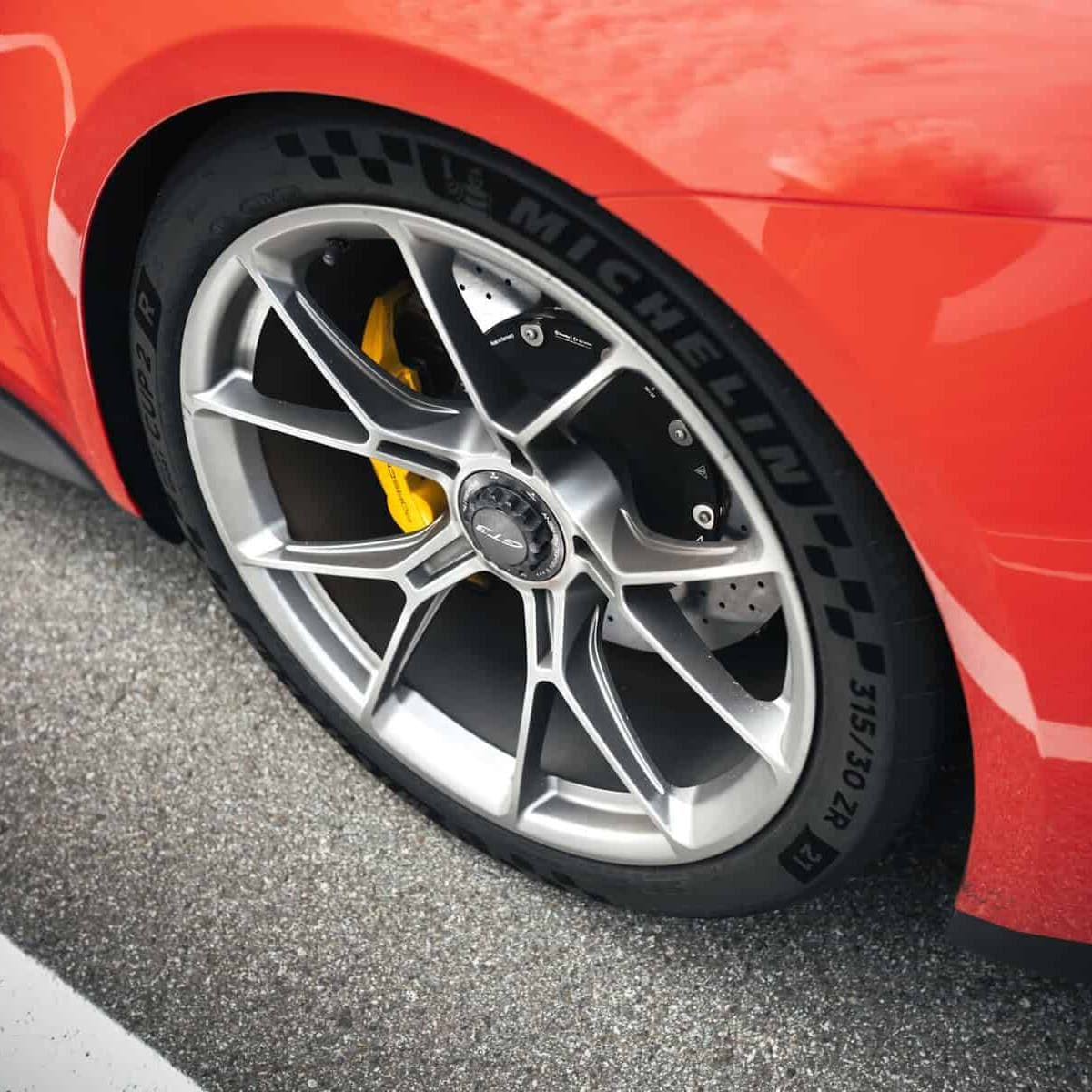 Close-up of a Porsche 911 GT3 rear wheel with centre-lock alloy, Michelin Pilot Sport Cup 2 tyre, and yellow ceramic brake caliper.