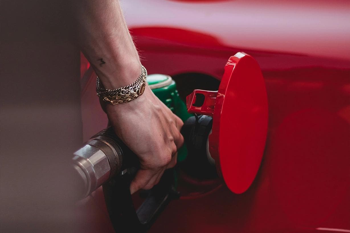 Close-up of a driver refuelling a car, highlighting the importance of using the correct octane to prevent detonation and pre-ignition.