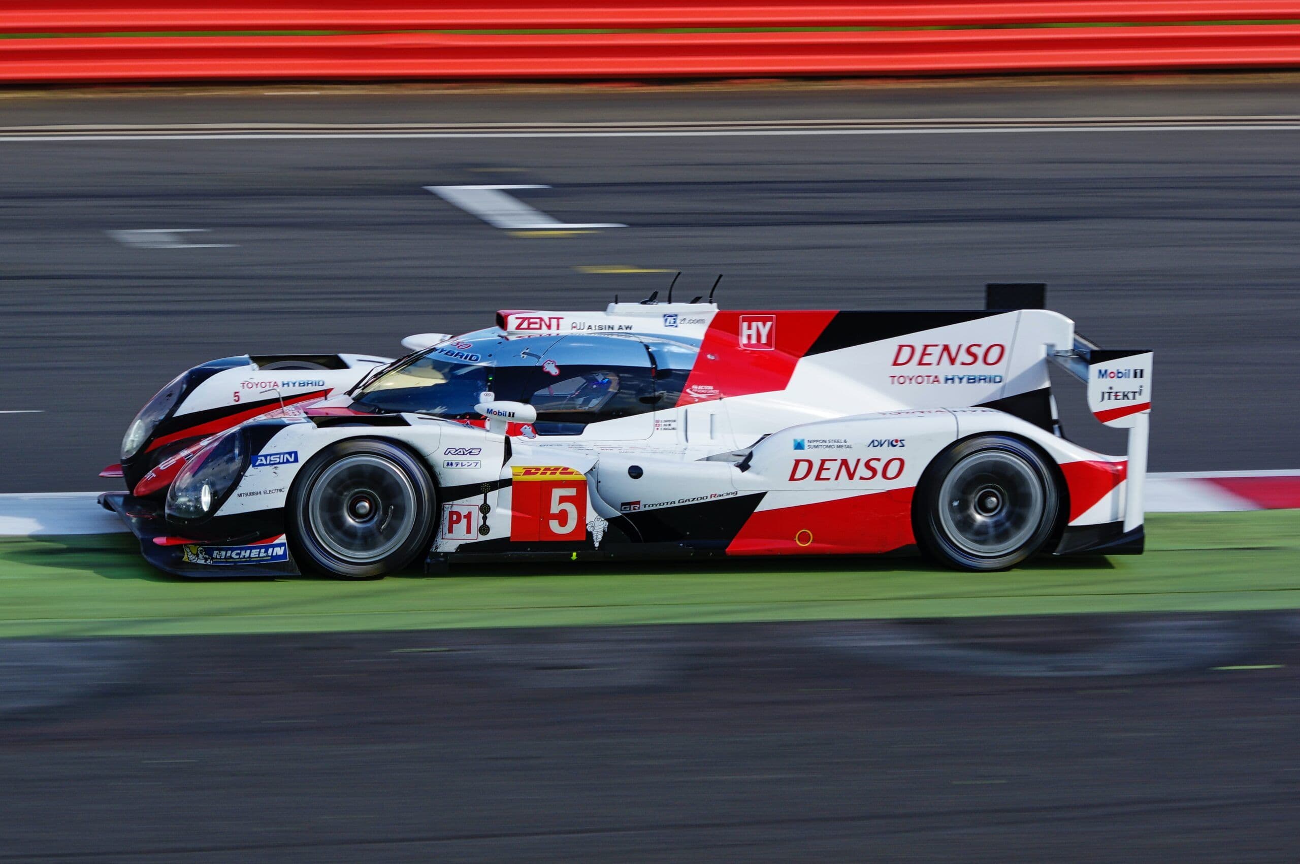 Side view of the Toyota TS050 Hybrid LMP1 endurance race car on track, captured in motion with the number 5 livery, featuring aerodynamic bodywork and sponsor decals.
