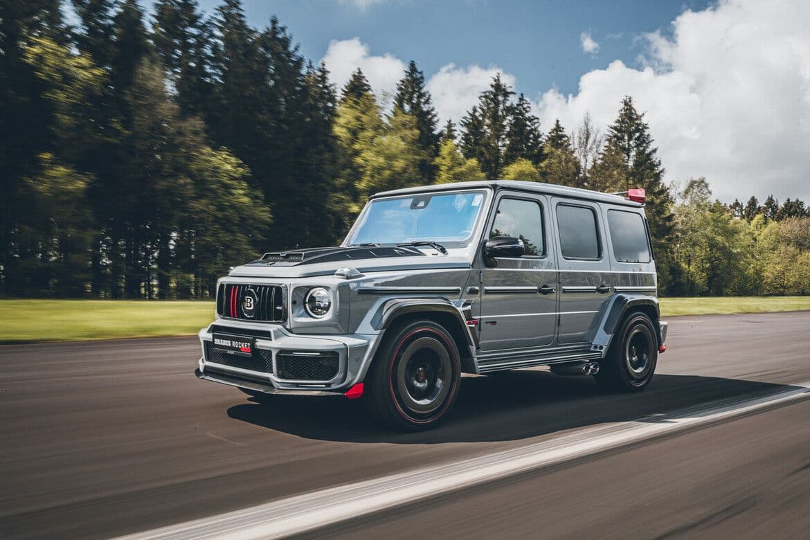 Brabus 900 Rocket Edition G-Class driving on track, featuring aggressive widebody styling and red accents.
