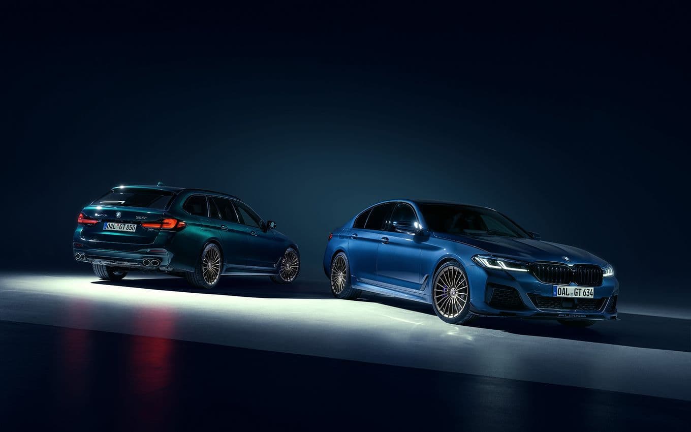 BMW ALPINA B5 GT in blue and touring trim under moody studio lighting, showcasing aerodynamic kit and multi-spoke wheels.