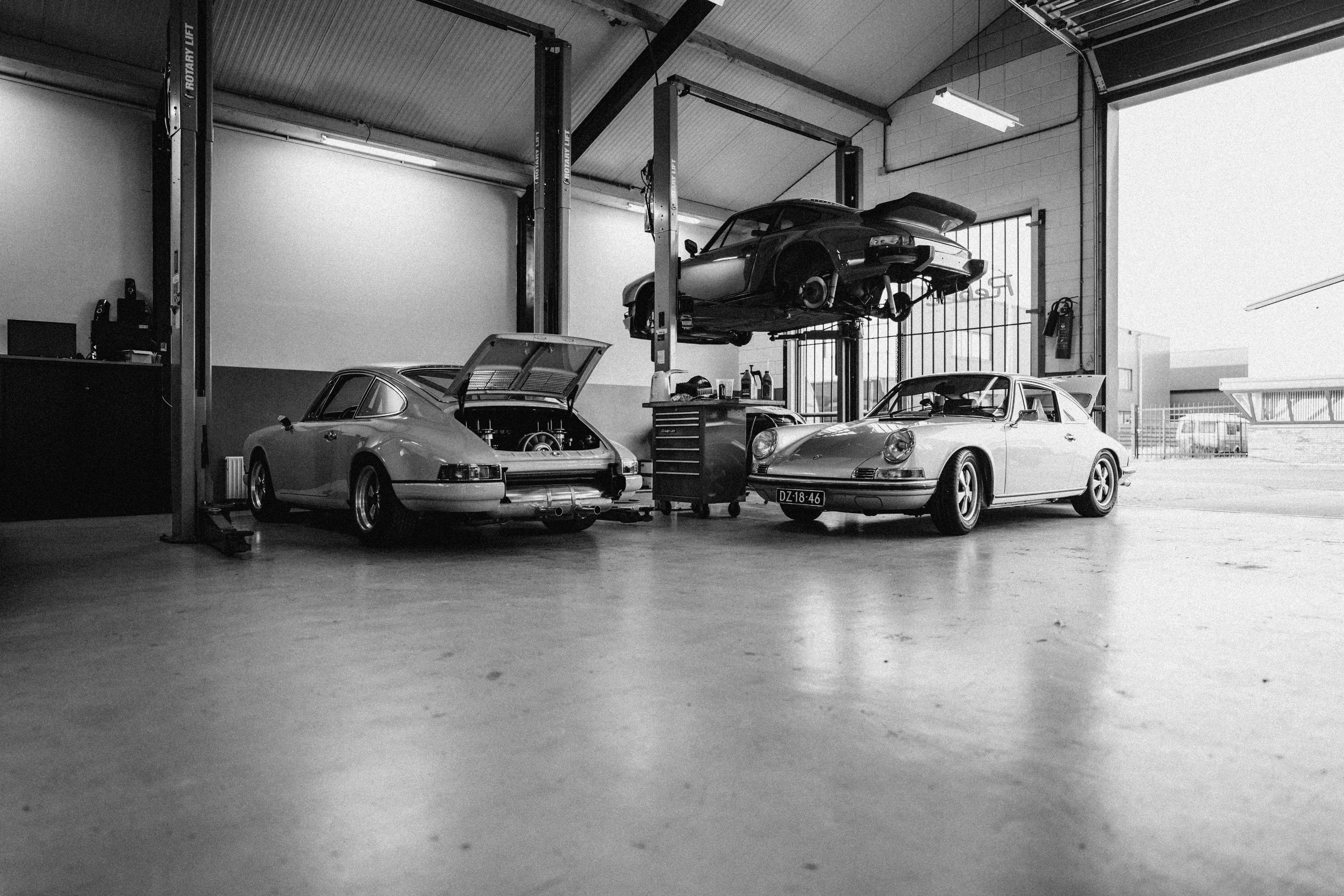 Classic Porsche 911s undergoing restoration in a professional workshop.