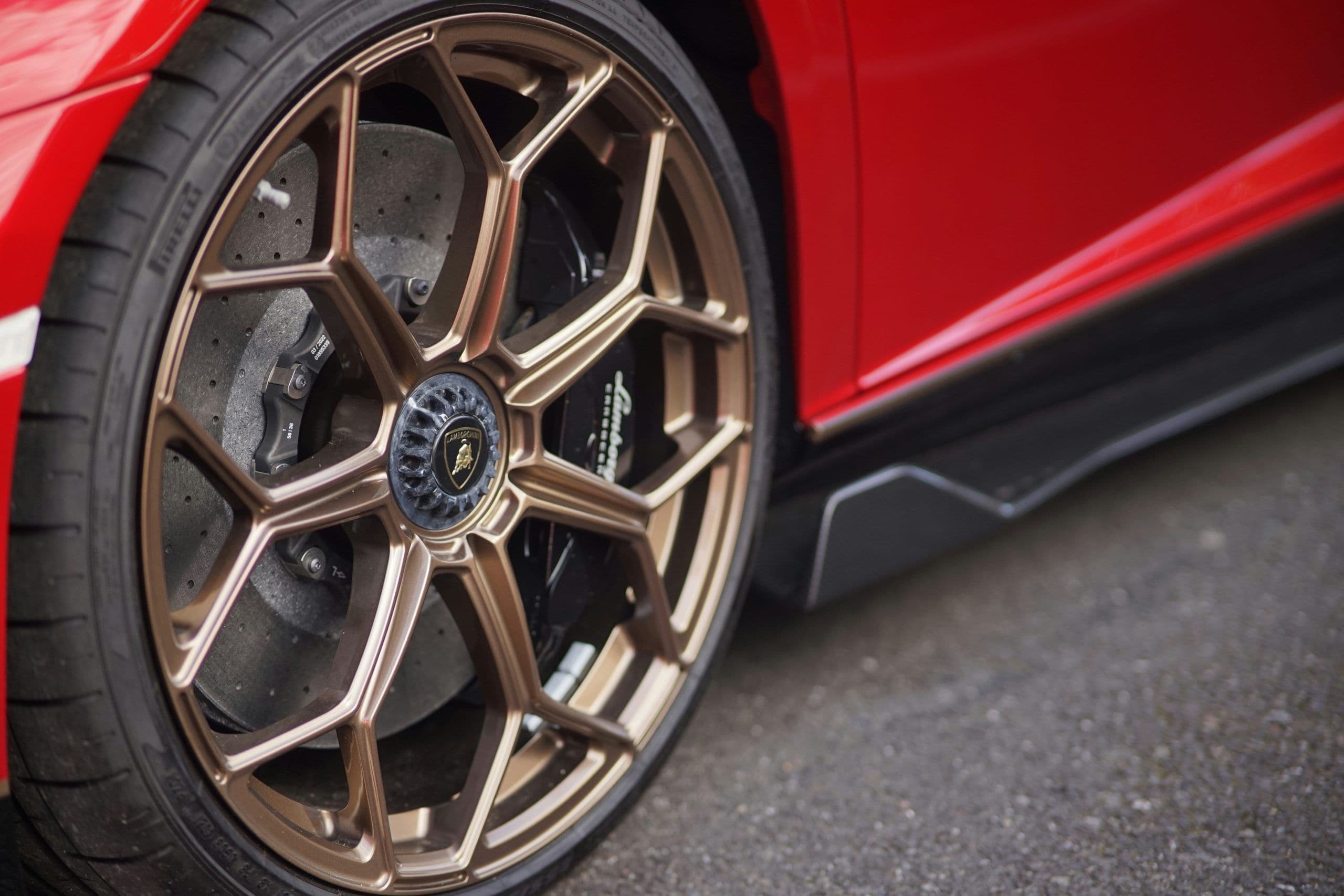 Close-up of bronze Lamborghini Aventador SVJ wheel with carbon-ceramic brakes.