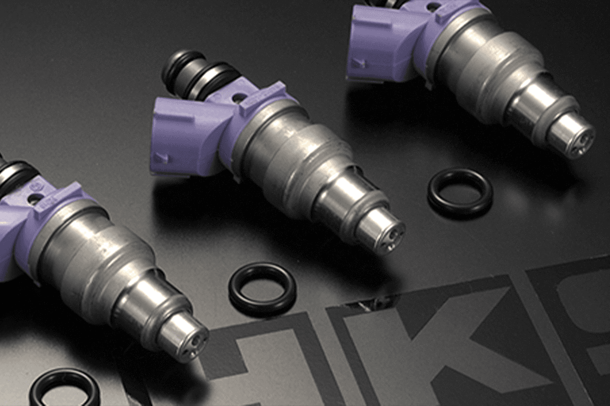 Set of HKS high-flow fuel injectors with purple connectors and O-rings, designed for performance tuning applications