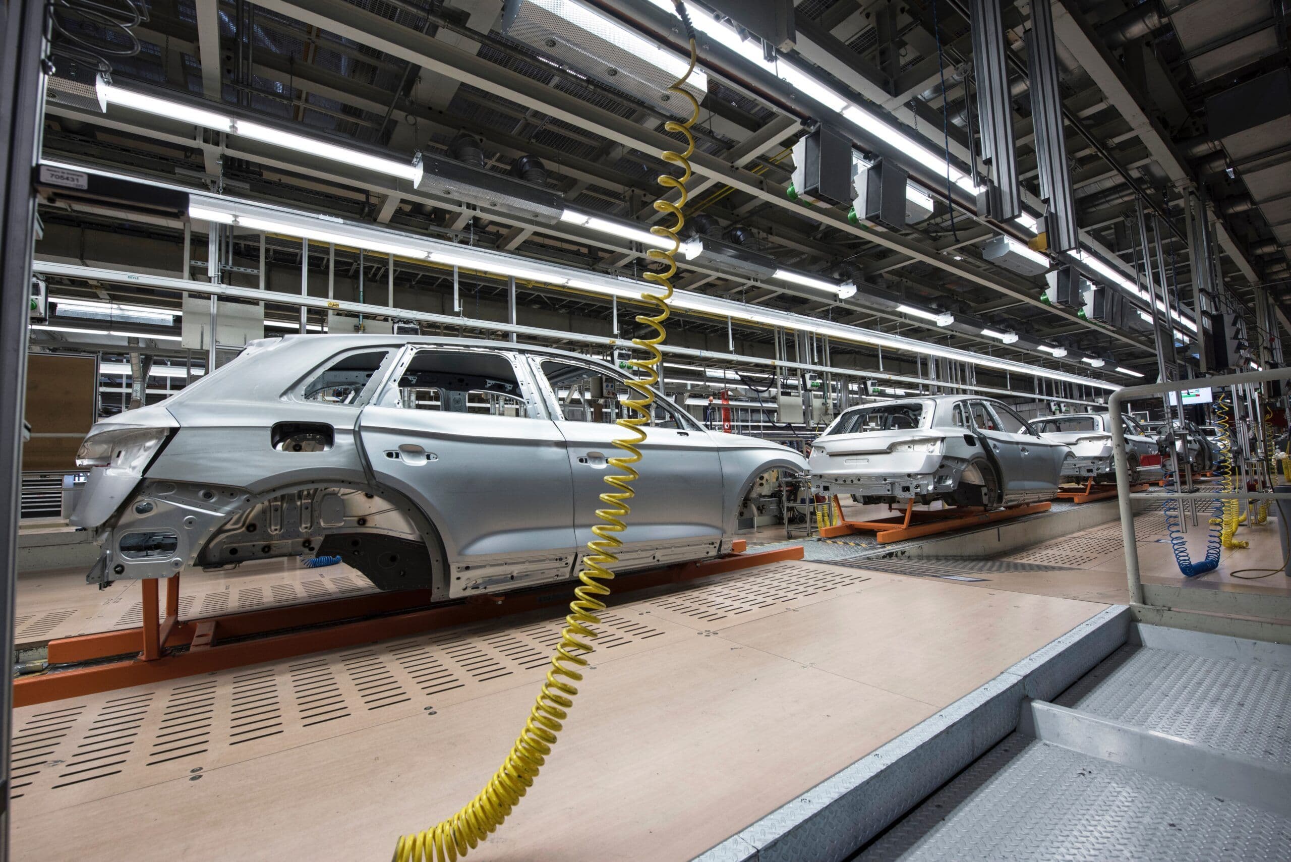 Automotive manufacturing plant with Audi SUV body shells on the assembly line under industrial lighting