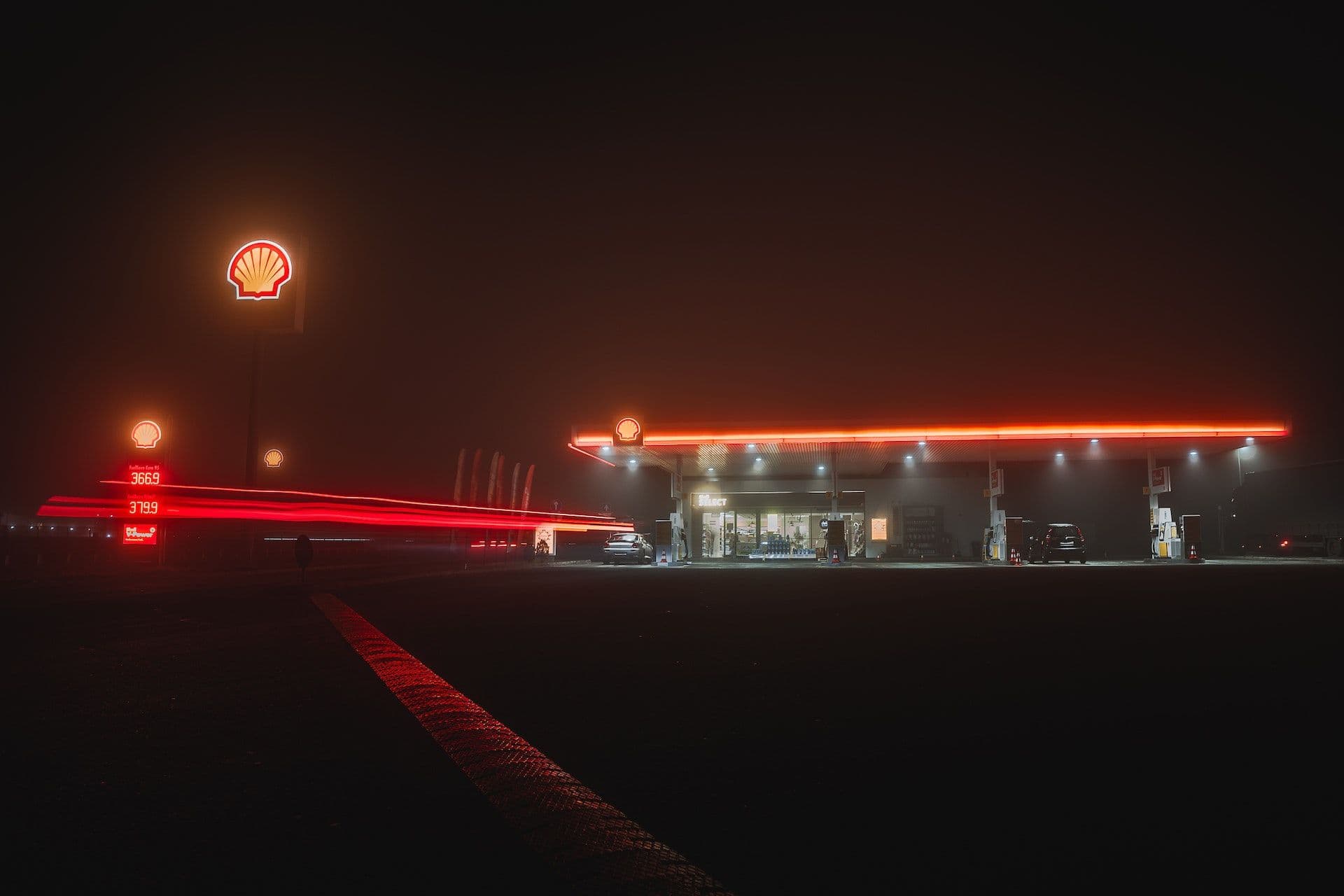 Shell petrol station at night with illuminated signage and fuel prices visible