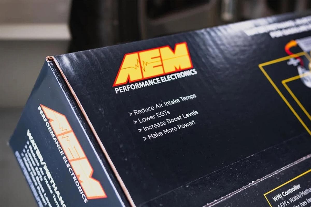 AEM Performance Electronics water methanol injection kit box showing claims to reduce intake temps, lower EGTs, and increase boost.