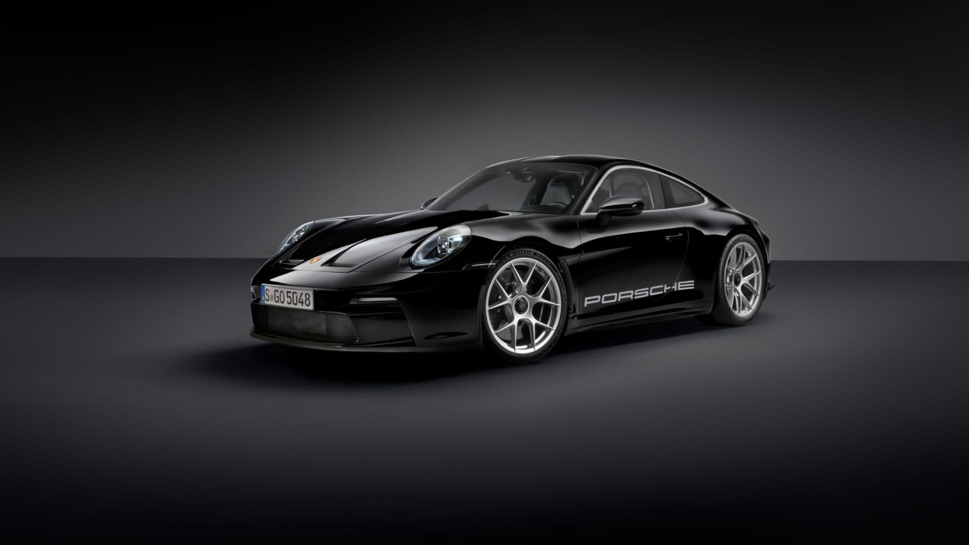 Front three-quarter view of black Porsche 911 ST 992, featuring anniversary livery in studio lighting.
