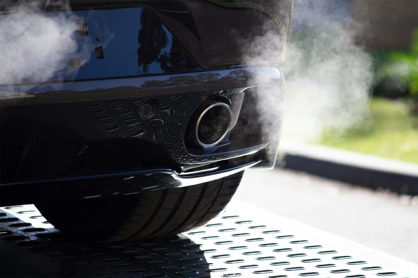 Close up of a car exhaust releasing visible emissions during a cold start.