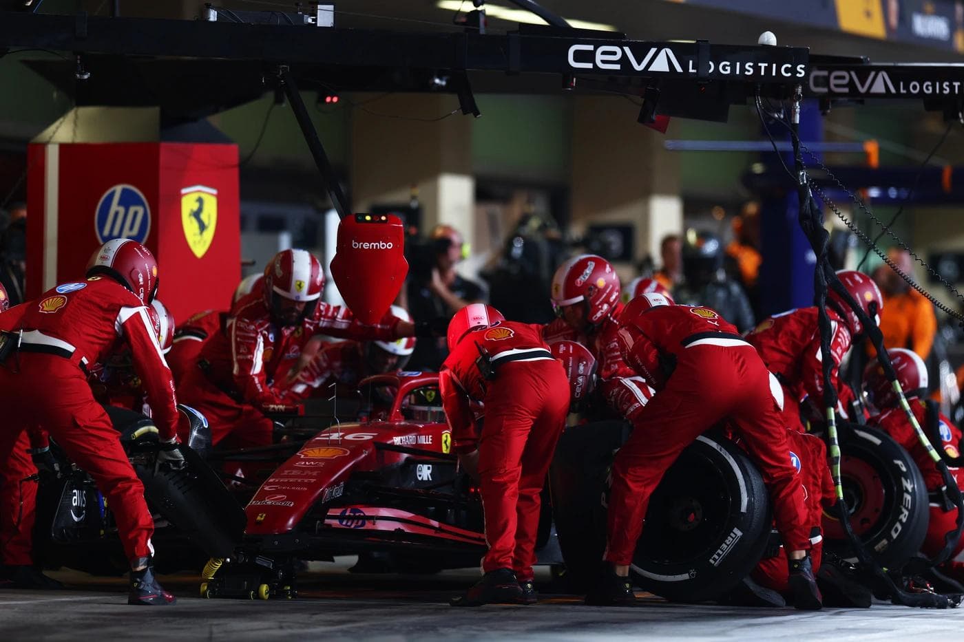 Scuderia Ferrari pit crew performing a race pit stop on car number 16 at Yas Marina Circuit during the 2025 Abu Dhabi Grand Prix, Pirelli P Zero tyre being fitted under the CEVA Logistics gantry